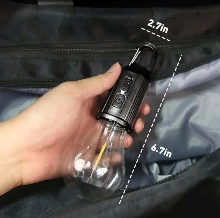 Person holding a Rechargeable LED Hanging Bulb with dimensions 2.7in x 6.7in, demonstrating its portable design.