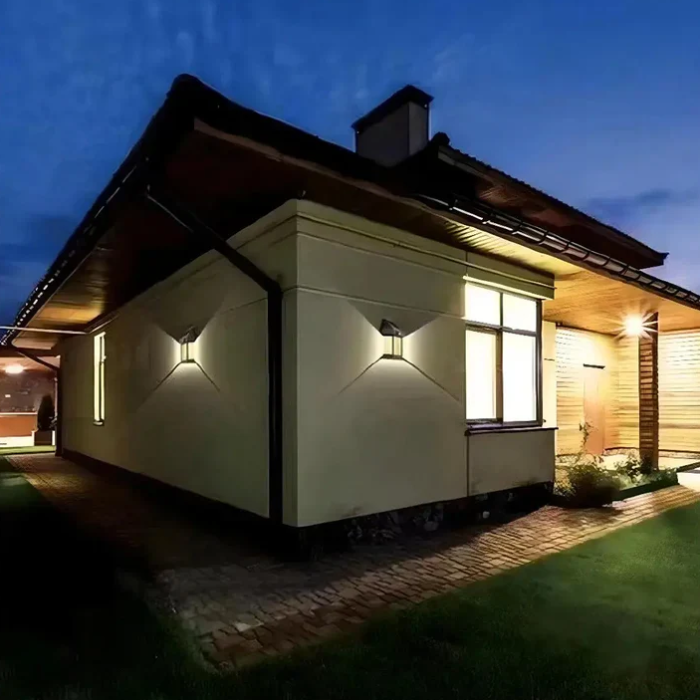 Exterior view of a home illuminated by wall-mounted solar lights in the evening, showcasing elegant outdoor lighting.